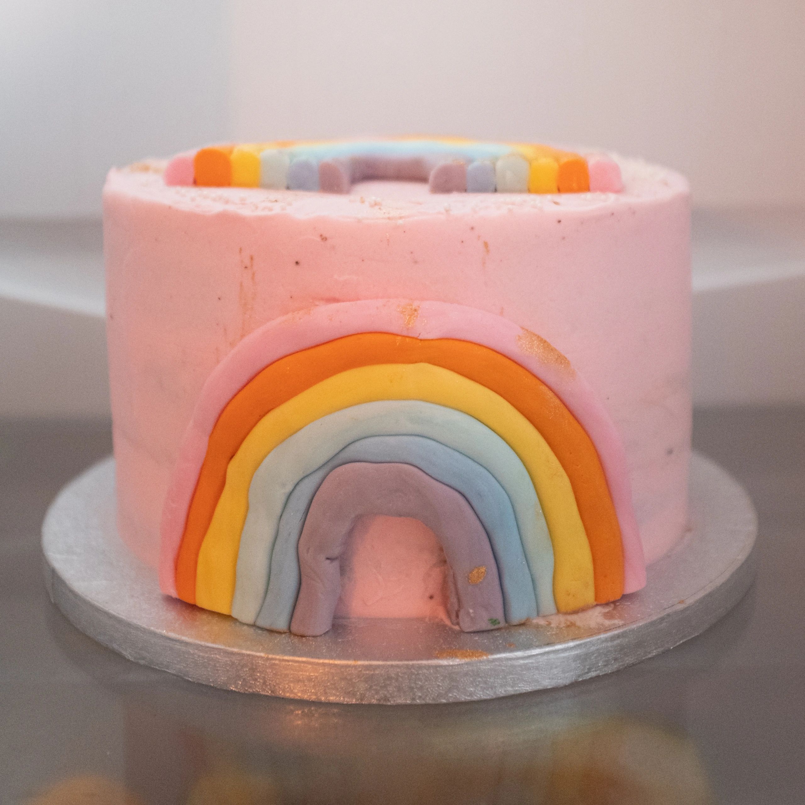 Bright pink rainbow-style cake for a birthday celebration
