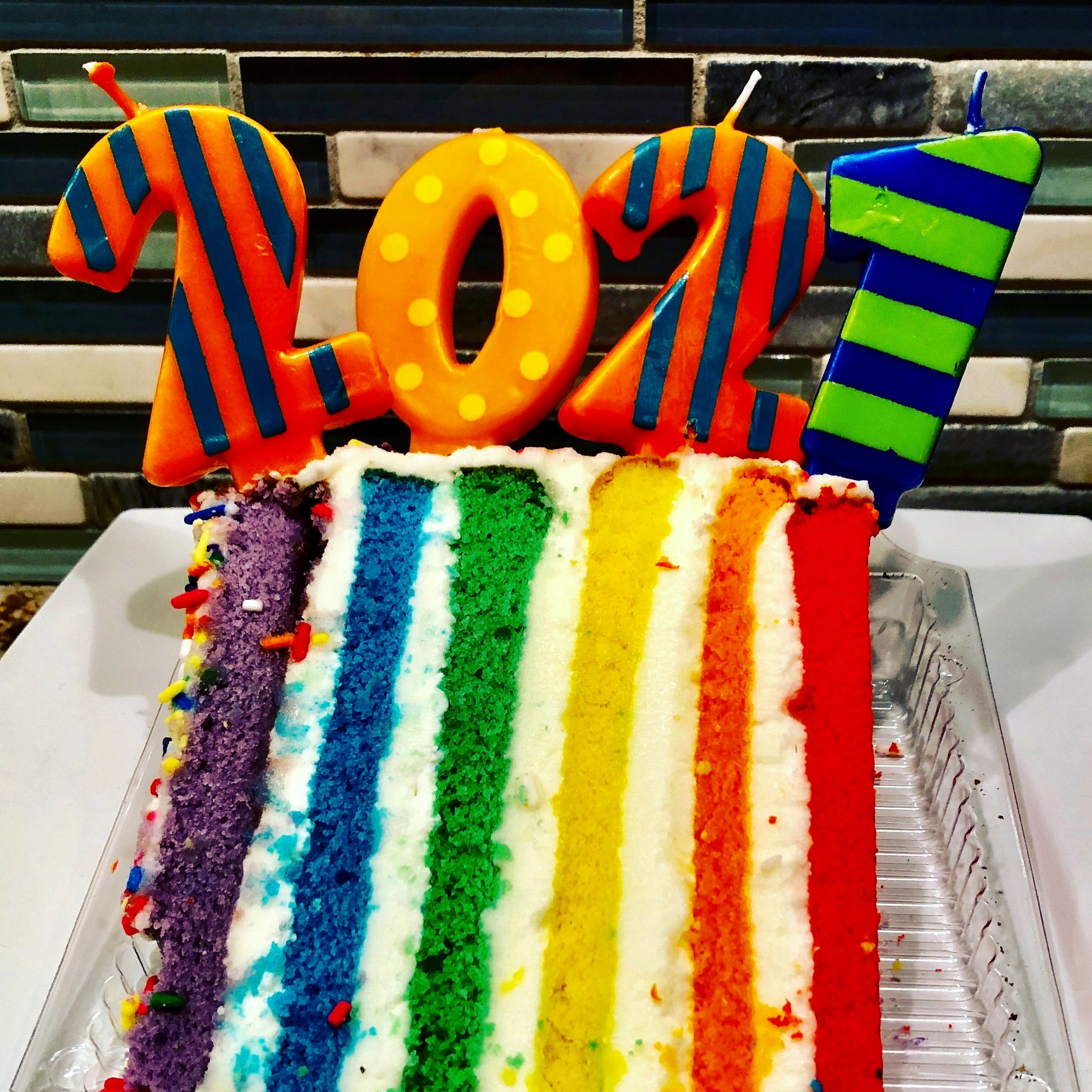 Bright rainbow layer cake slice with colorful layers