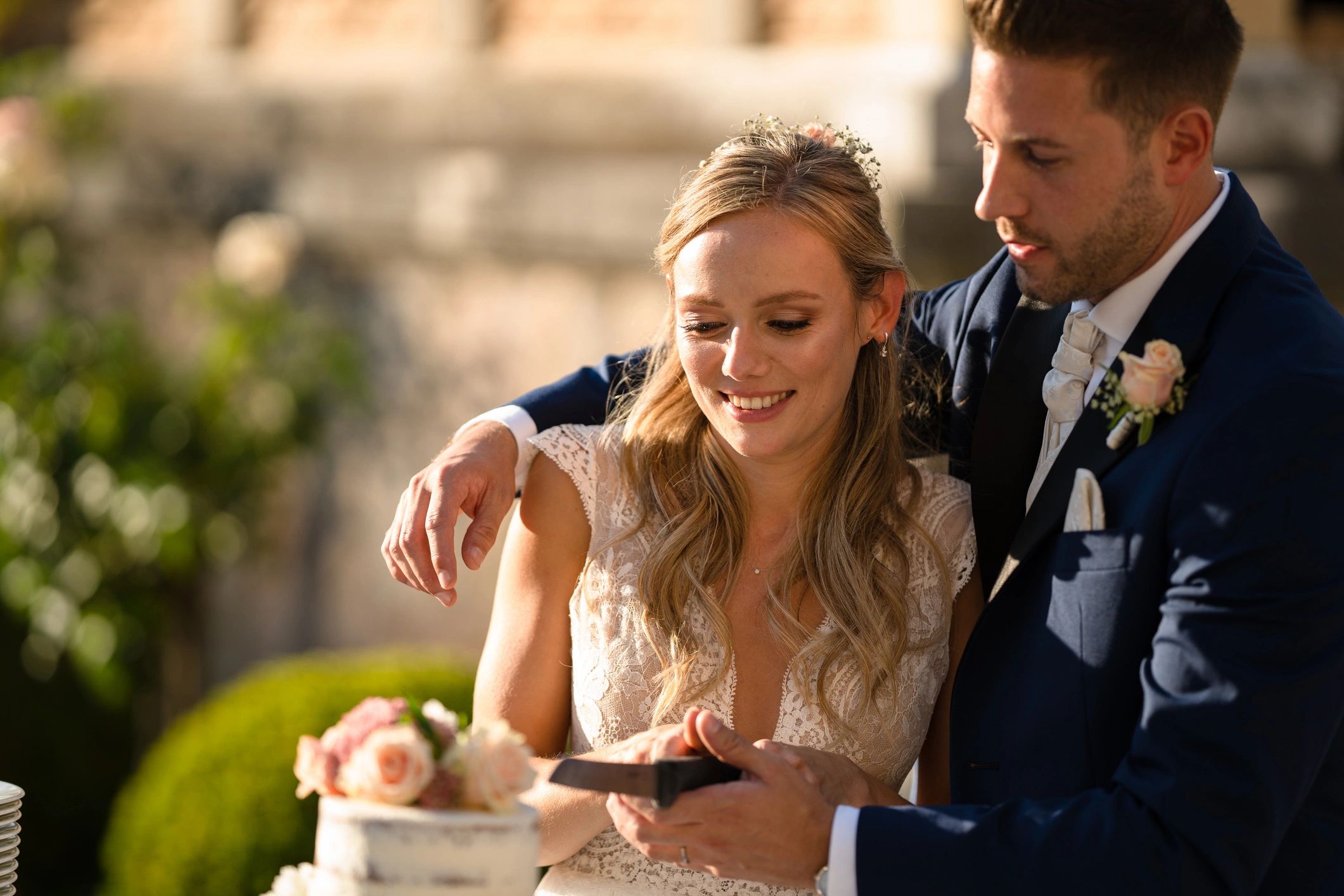 Couple cutting a wedding cake outdoors
