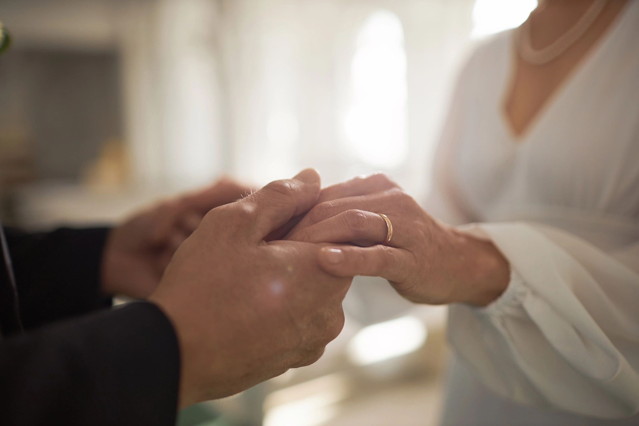Close-up of wedding rings on a couple holding hands