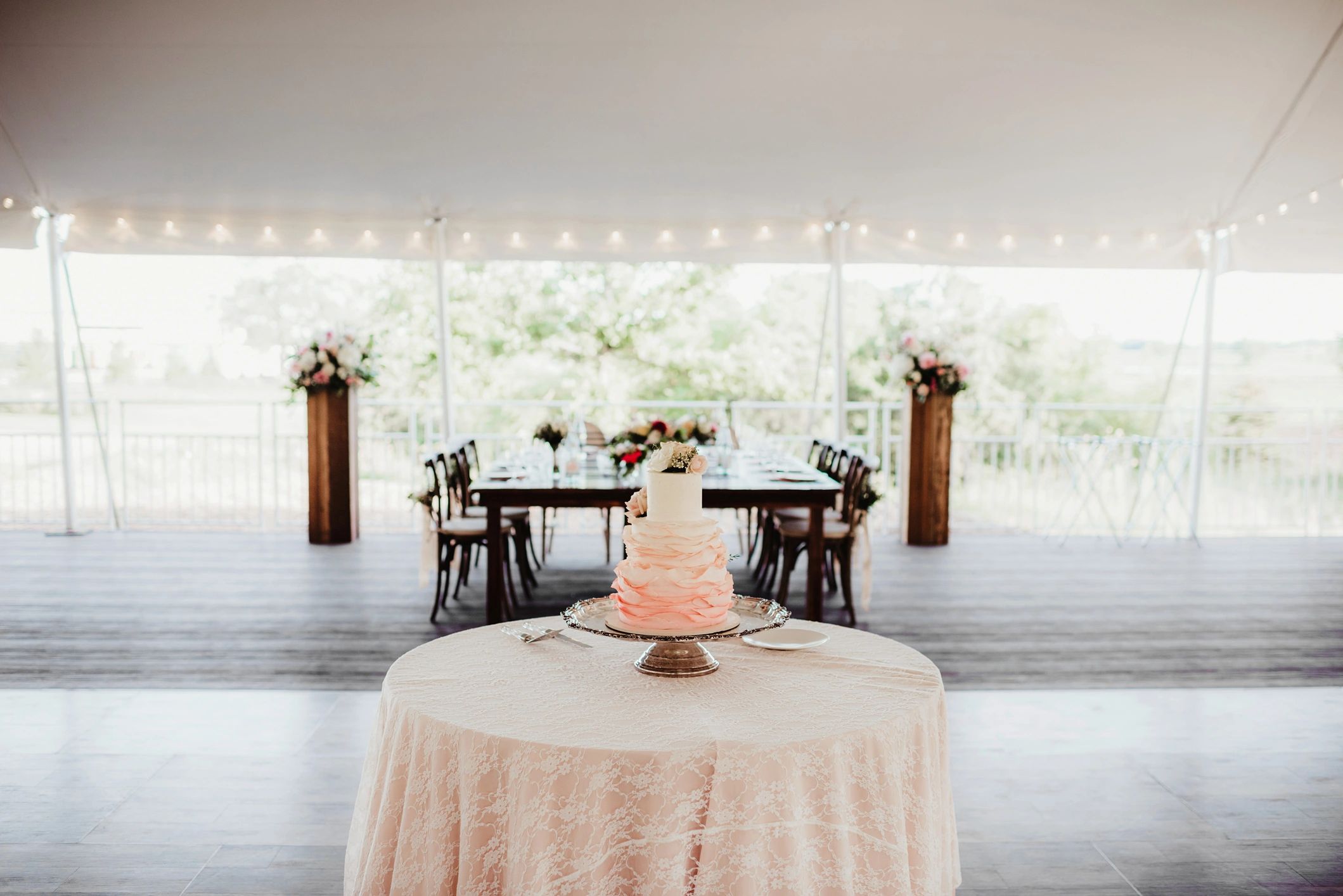 Dessert table with tiered wedding cake in a reception tent