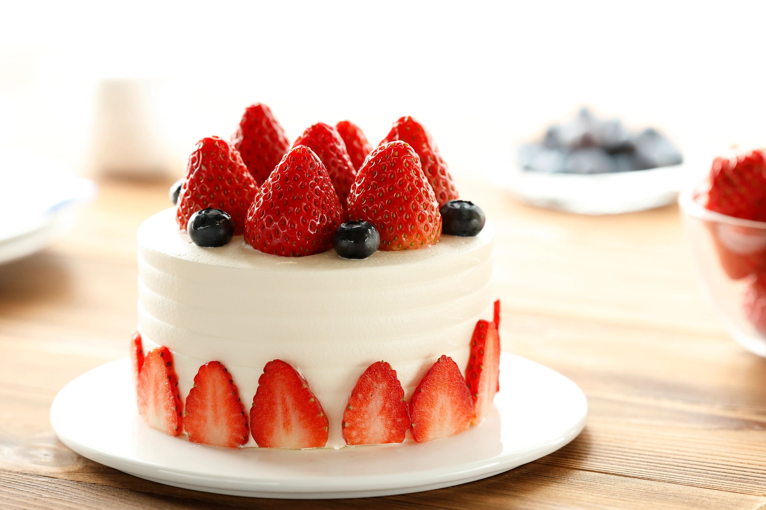 Cream cake decorated with strawberries and blueberries