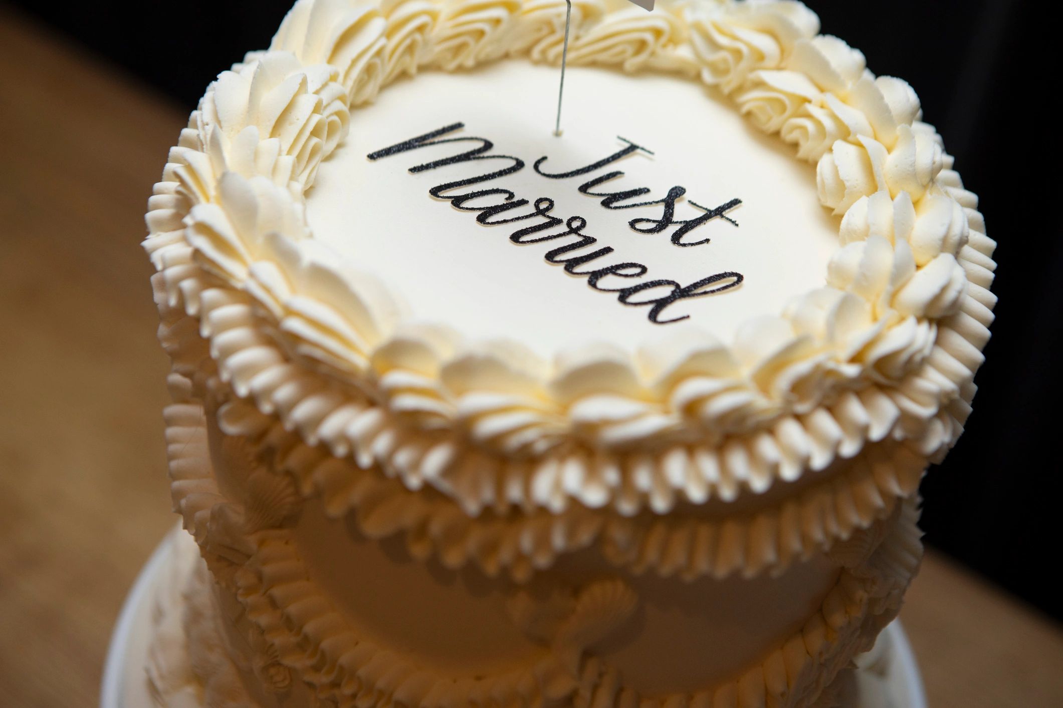 Top of a wedding cake with ornate buttercream icing