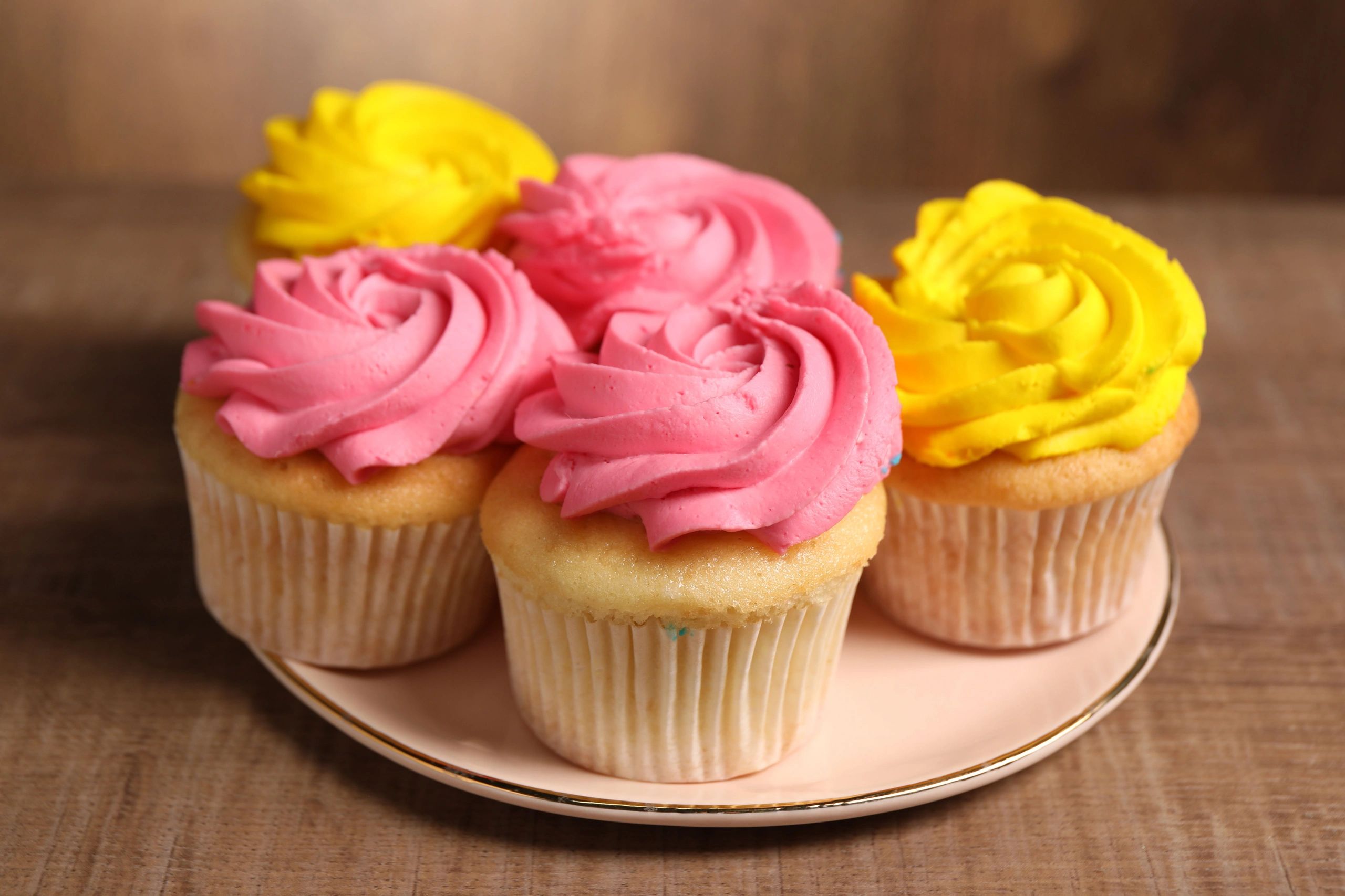 Cupcakes with bright frosting on a wooden table