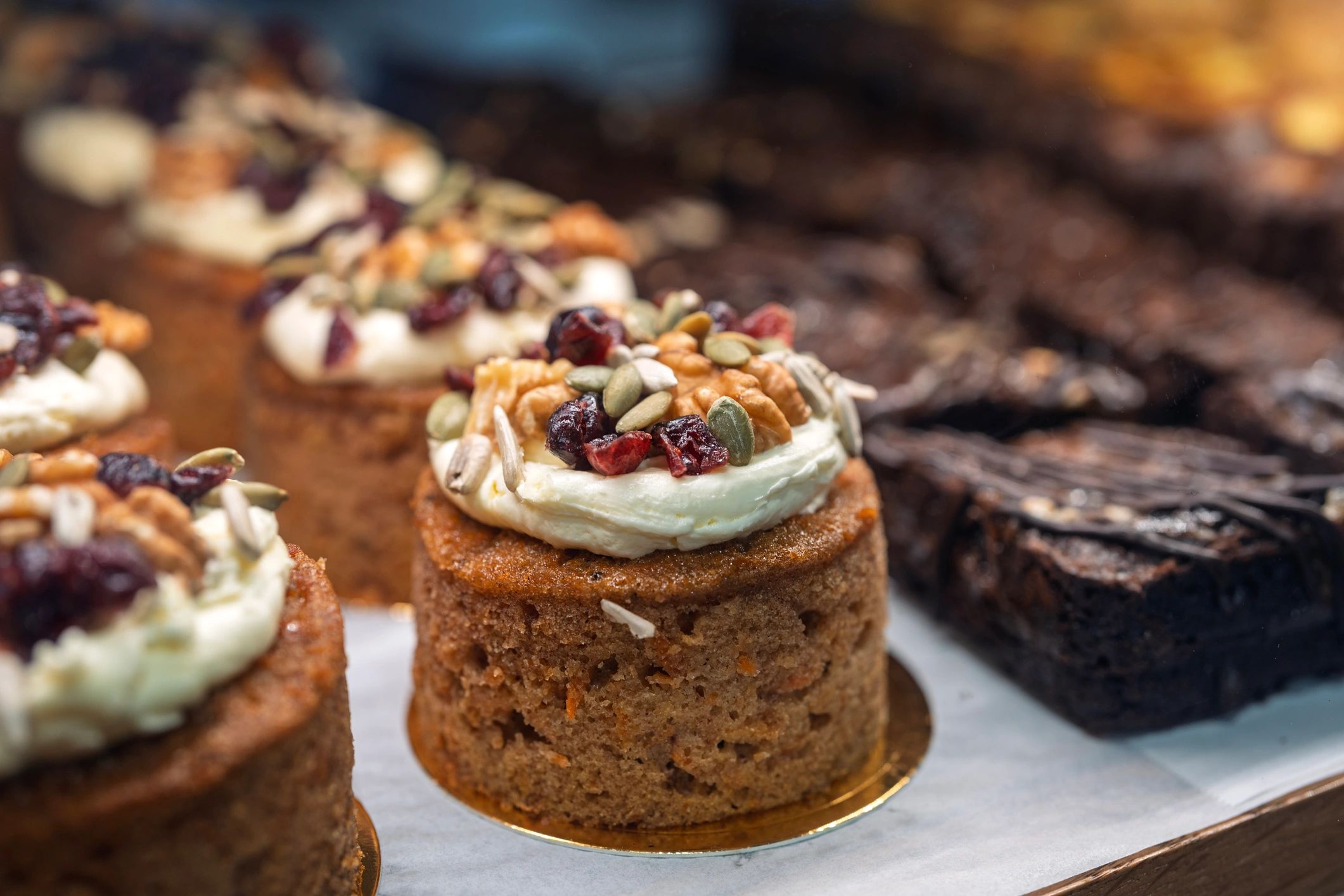 Mini carrot cakes topped with cream cheese frosting and nuts